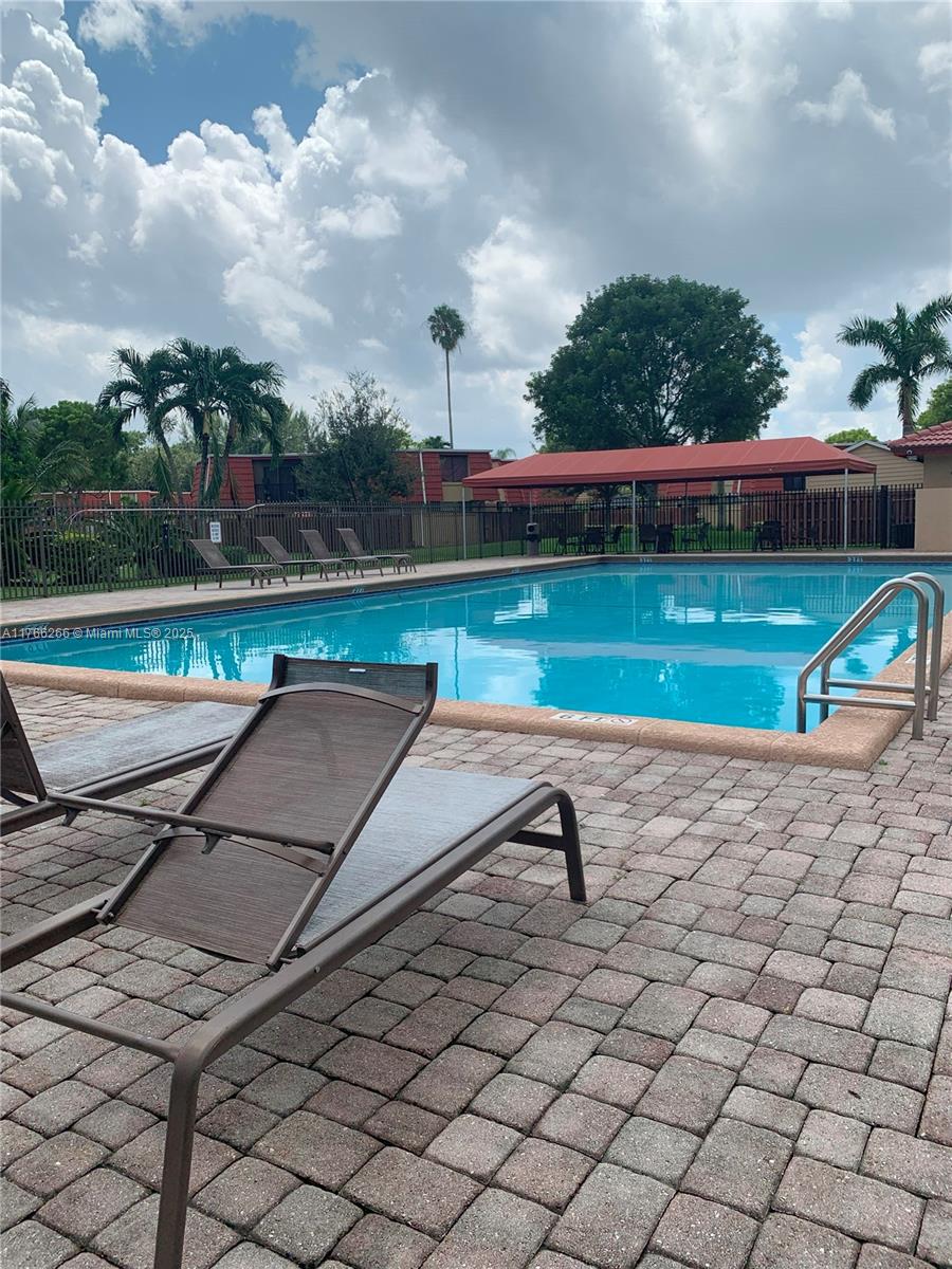 8063 Severn Drive, Unit D Boca Raton, FL 33433 - Photo 19 of 20 a view of swimming pool with a yard and a bench