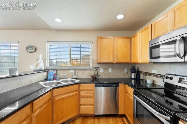 a kitchen with stainless steel appliances a sink stove and cabinets