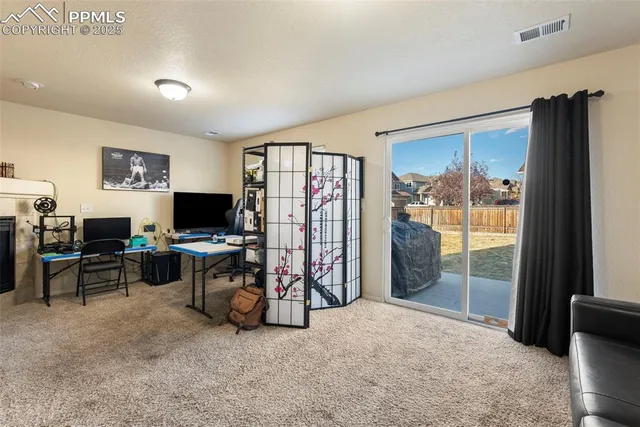 a view of a livingroom with workspace and a window