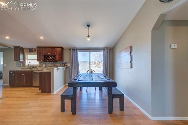 5860 Curtis Road Peyton, CO 80831 - Photo 10 of 28 Dining space featuring light wood finished floors, lofted ceiling, and baseboards