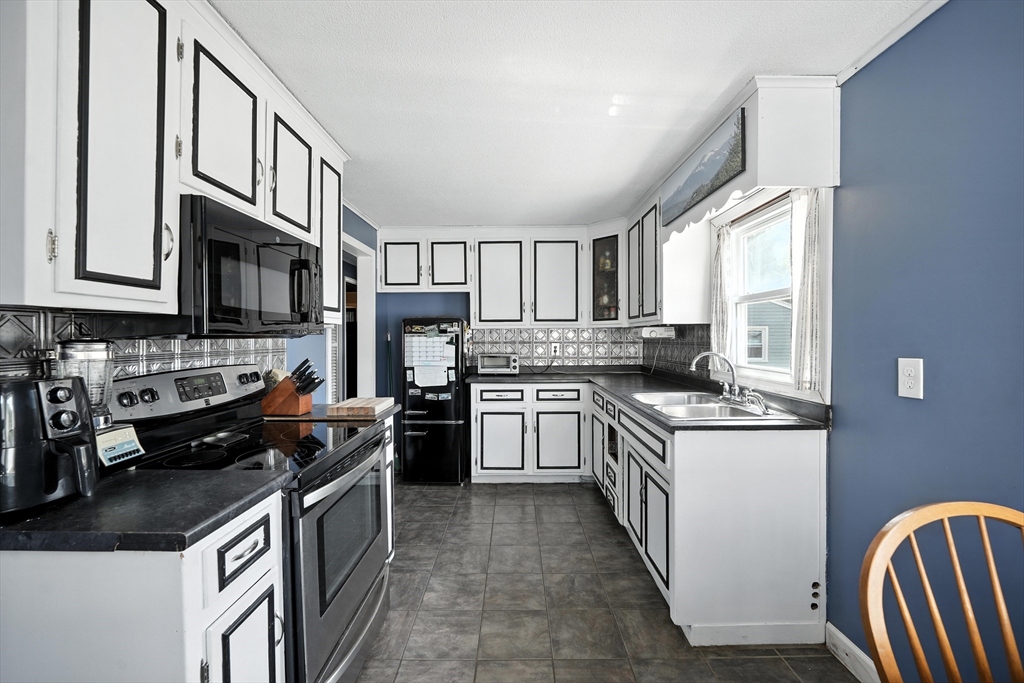 721 Pendleton Avenue Chicopee, MA 01020 - Photo 14 of 36 a kitchen with stainless steel appliances granite countertop a stove top oven a sink dishwasher a refrigerator and cabinets with wooden floor