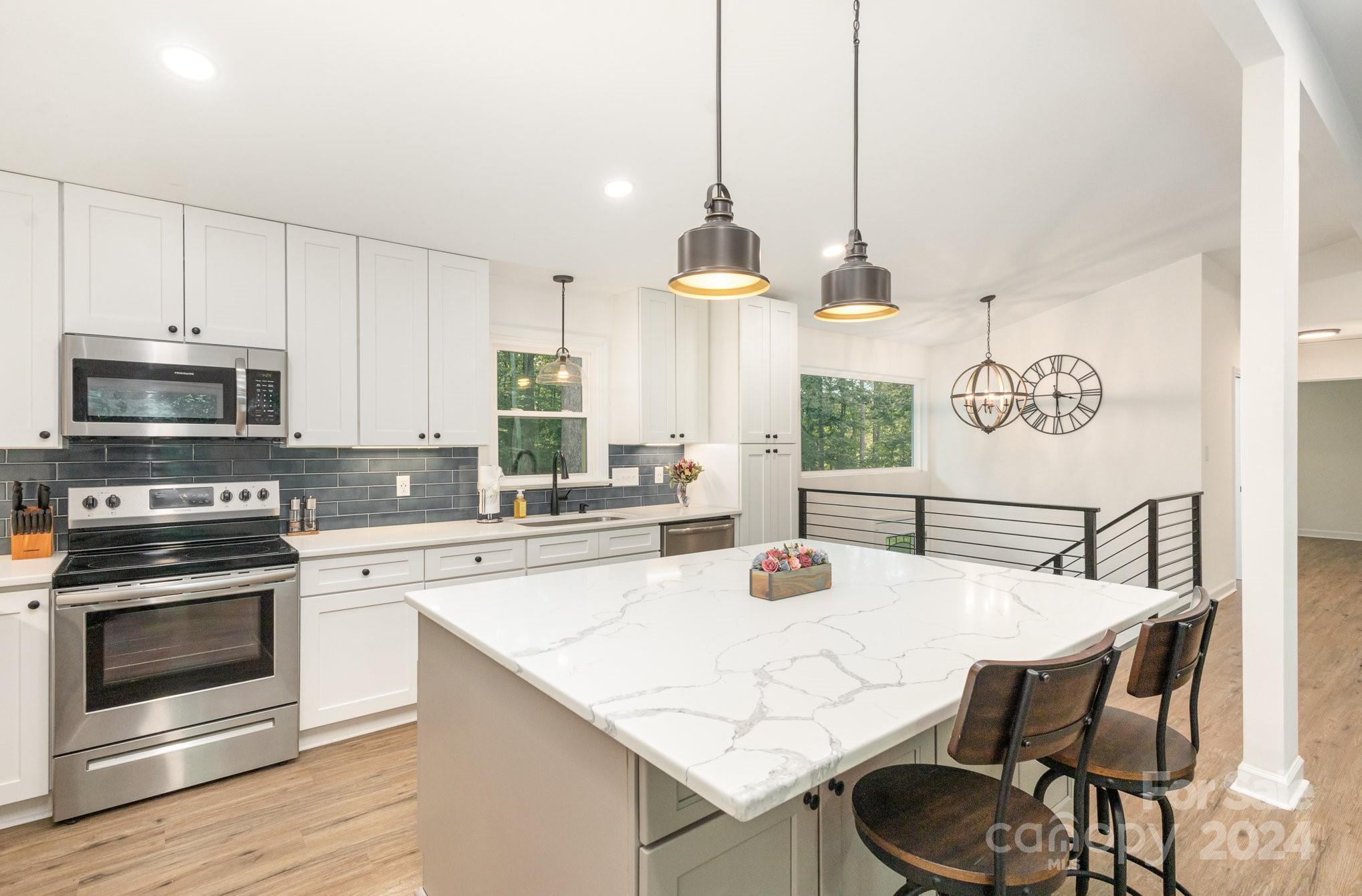 10625 East Lake Road Charlotte, NC 28215 - Photo 13 of 44 a kitchen with kitchen island a stove a table and chairs in it