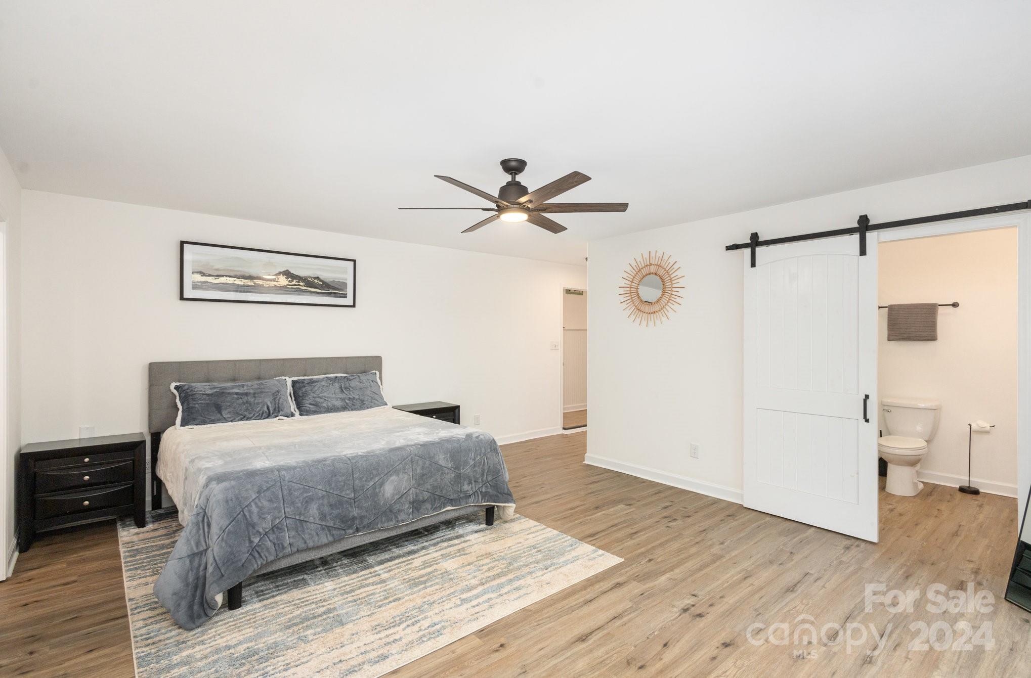 10625 East Lake Road Charlotte, NC 28215 - Photo 18 of 44 a bedroom with a bed and a ceiling fan