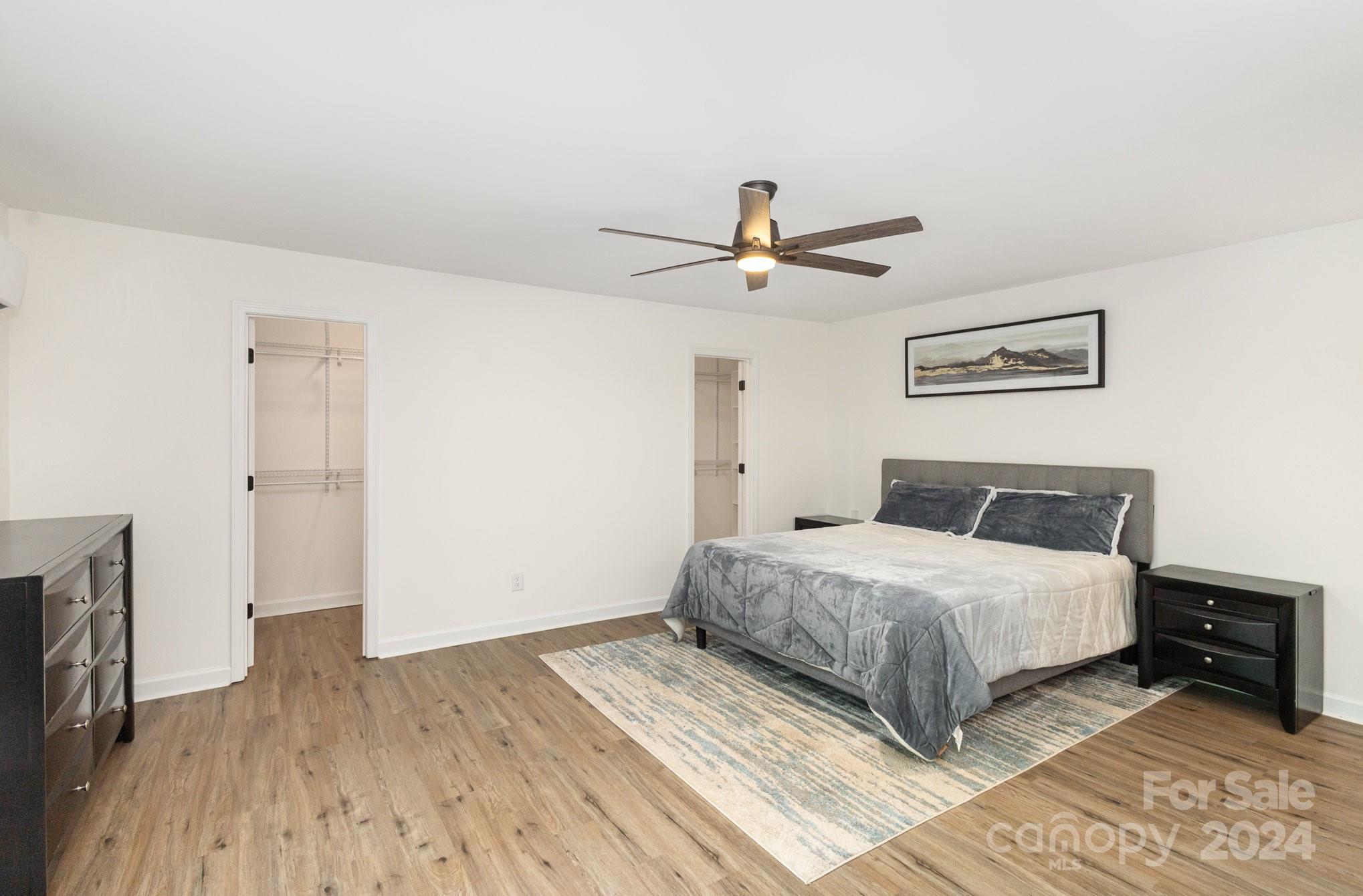 10625 East Lake Road Charlotte, NC 28215 - Photo 19 of 44 a bedroom with a large bed and a ceiling fan