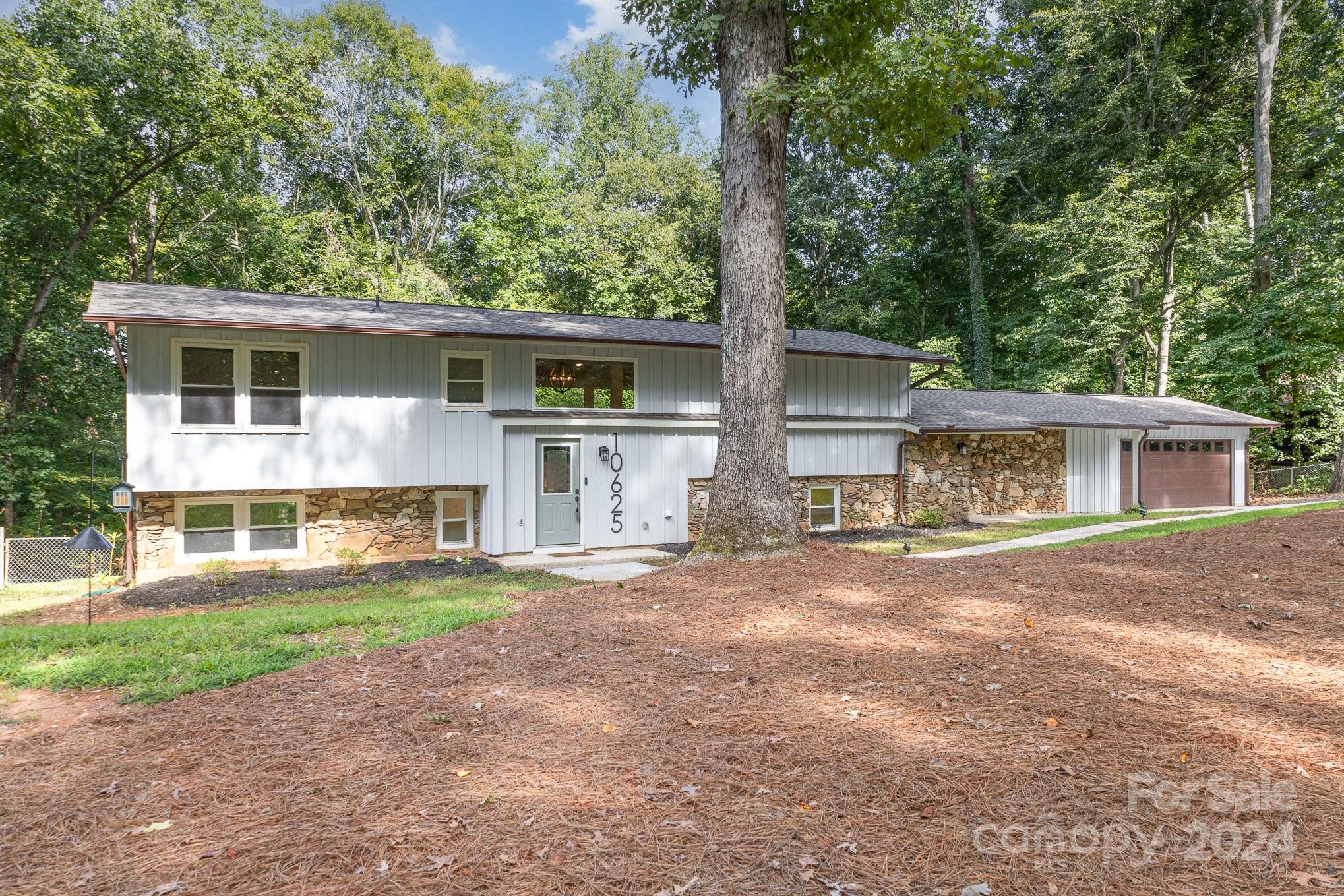 10625 East Lake Road Charlotte, NC 28215 - Photo 2 of 44 a view of a yard in front of a house with large windows