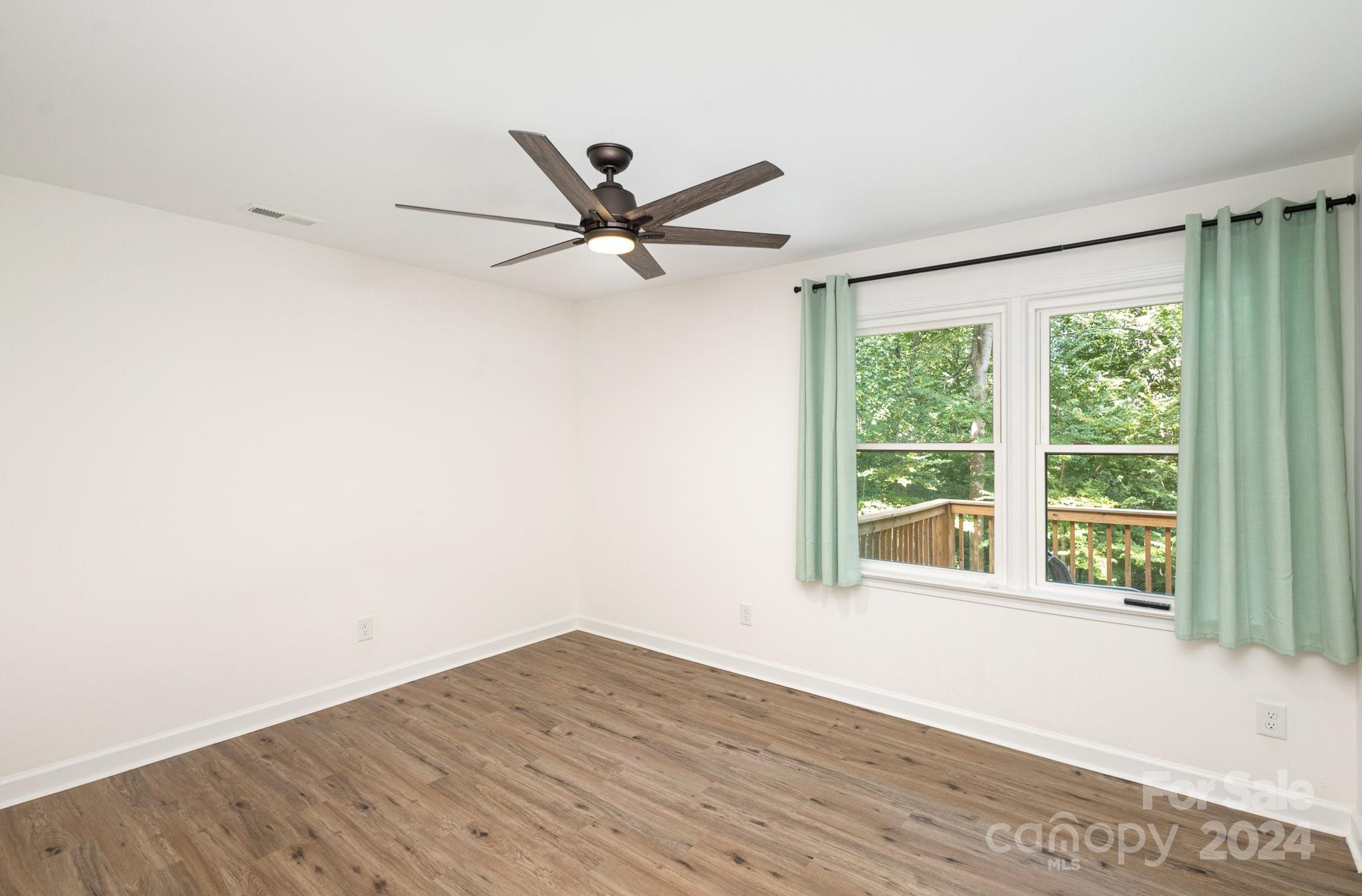 10625 East Lake Road Charlotte, NC 28215 - Photo 26 of 44 a view of a room with wooden floor and a ceiling fan
