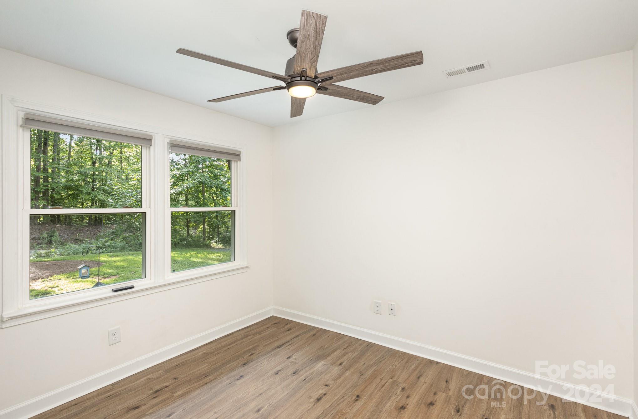10625 East Lake Road Charlotte, NC 28215 - Photo 27 of 44 an empty room with wooden floor fan and windows