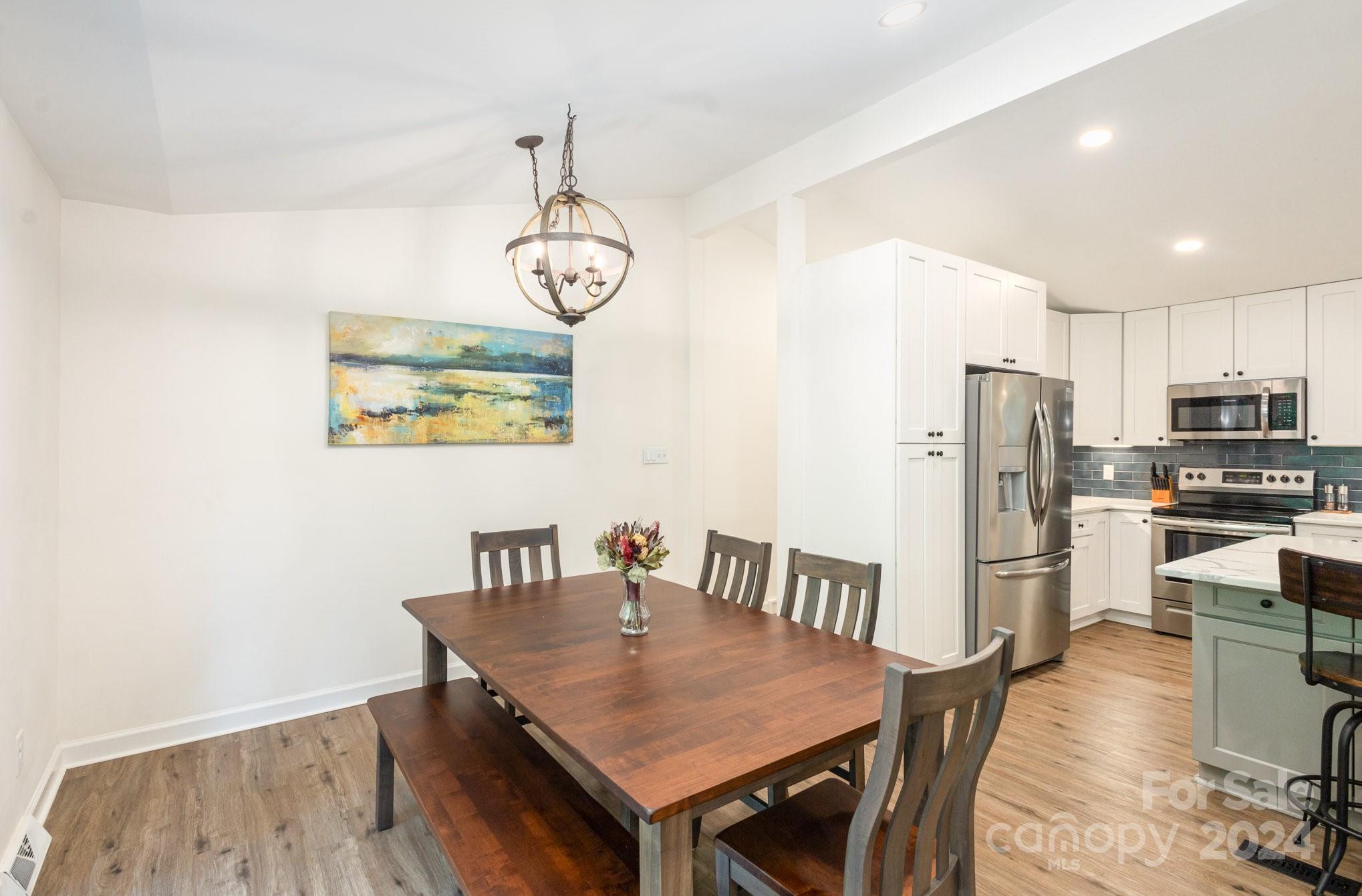 10625 East Lake Road Charlotte, NC 28215 - Photo 10 of 44 a view of a dining room with furniture kitchen and wooden floor