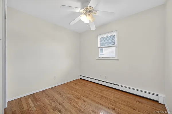 an empty room with a window and a fan