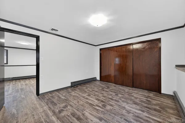 a view of empty room with wooden floor