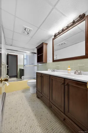 a bathroom with a sink double vanity granite and a large mirror