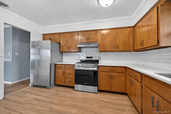a kitchen with stainless steel appliances granite countertop a stove a sink and a refrigerator