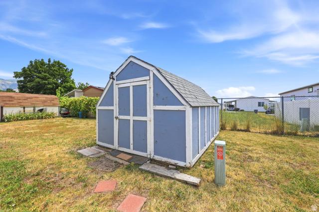 2491 Highway 89, Unit 614 Pleasant View, UT 84404 - Photo 23 of 27 Blue painted storage shed with a gabled roof and light gray shingles