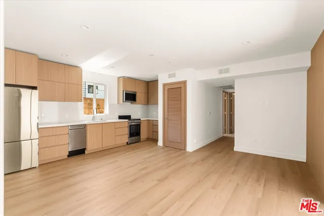 a kitchen with stainless steel appliances a refrigerator and a stove top oven