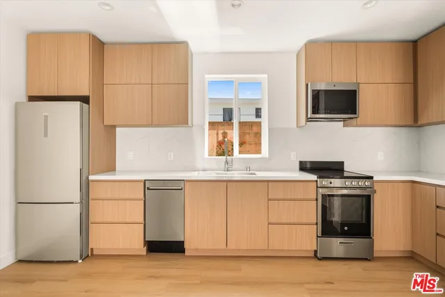 a kitchen with stainless steel appliances granite countertop a stove a sink and a refrigerator
