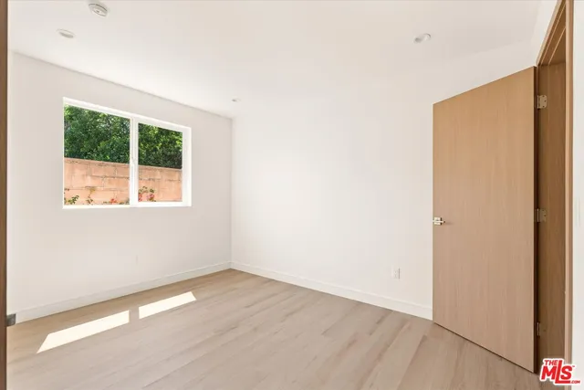 an empty room with wooden floor and a window