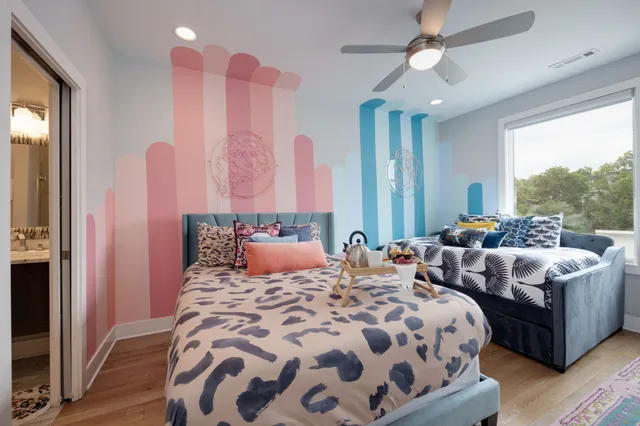 a bedroom with a bed and painting on the wall