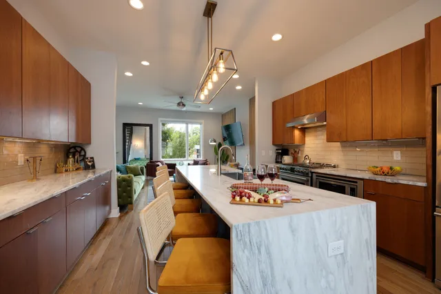 a kitchen with kitchen island granite countertop a sink appliances and cabinets