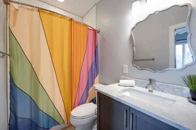 a living room with chairs and paintings on the wall