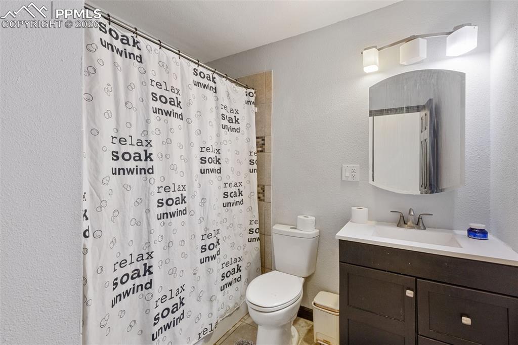 336 Harvard Street Colorado Springs, CO 80911 - Photo 18 of 27 a bathroom with a shower curtain sink and a toilet