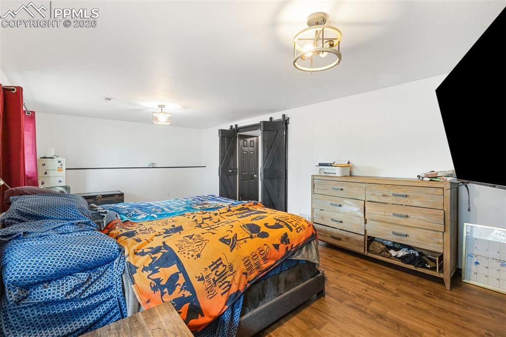 336 Harvard Street Colorado Springs, CO 80911 - Photo 20 of 27 a bedroom with a bed and wooden floor