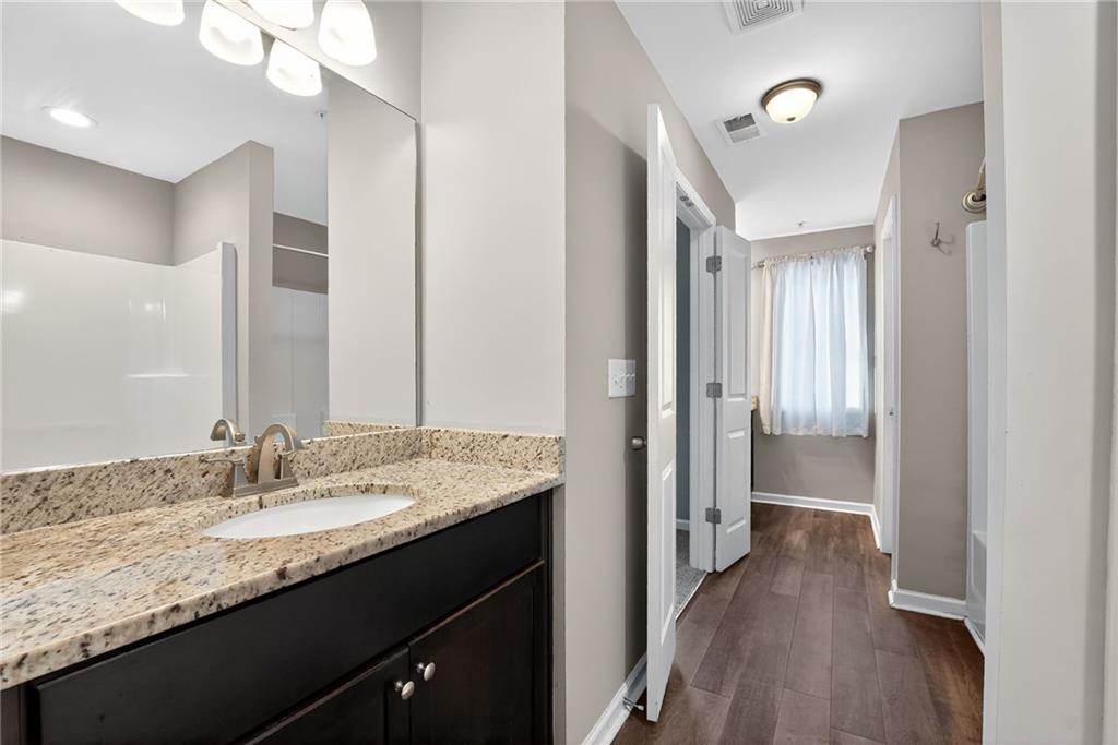 3369 Hidden Stream Court Stockbridge, GA 30281 - Photo 13 of 22 a en suite bathroom with a granite countertop sink a mirror and a shower