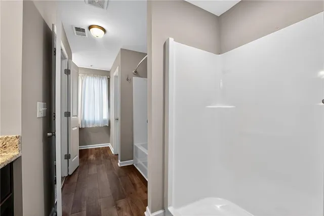 a view of a hallway with wooden floor and staircase