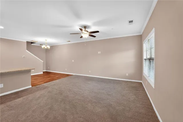 an empty room with windows and ceiling fan