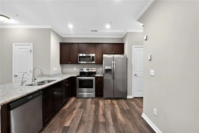 a kitchen with granite countertop a refrigerator and a sink
