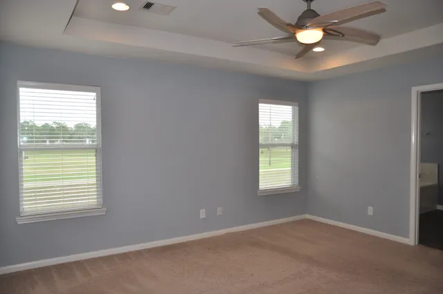 an empty room with a window and a fan