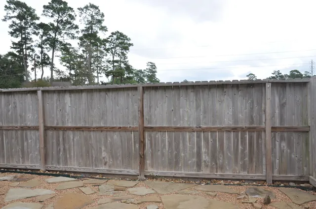 a view of backyard with wooden fence
