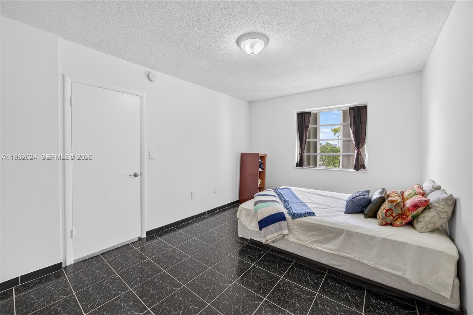 3181 Southwest 13th Street, Unit 416 Miami, FL 33145 - Photo 13 of 40 a bedroom with a bed and a window