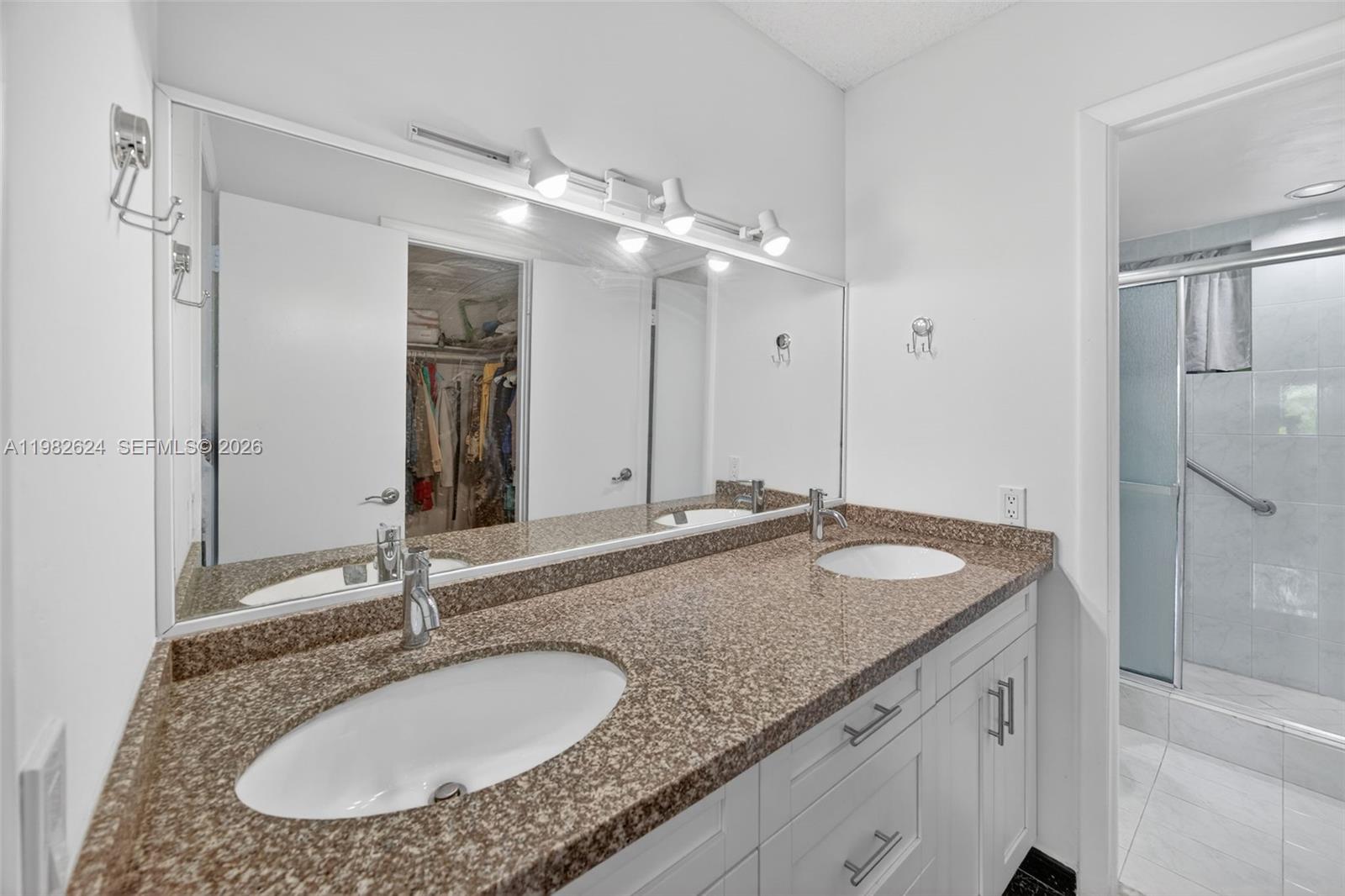 3181 Southwest 13th Street, Unit 416 Miami, FL 33145 - Photo 16 of 40 a bathroom with a granite countertop double vanity and a mirror