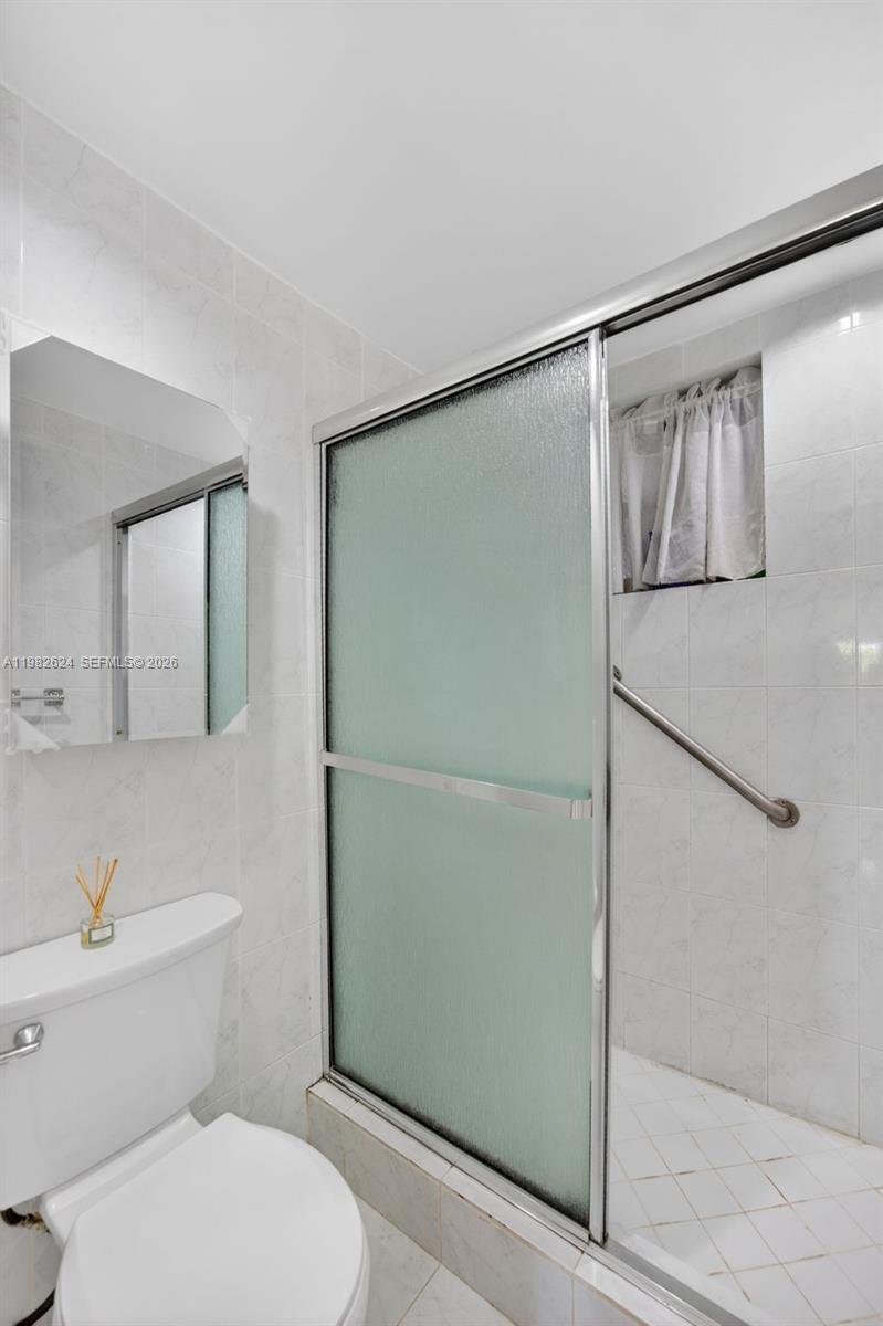 3181 Southwest 13th Street, Unit 416 Miami, FL 33145 - Photo 19 of 40 a bathroom with a toilet and a shower
