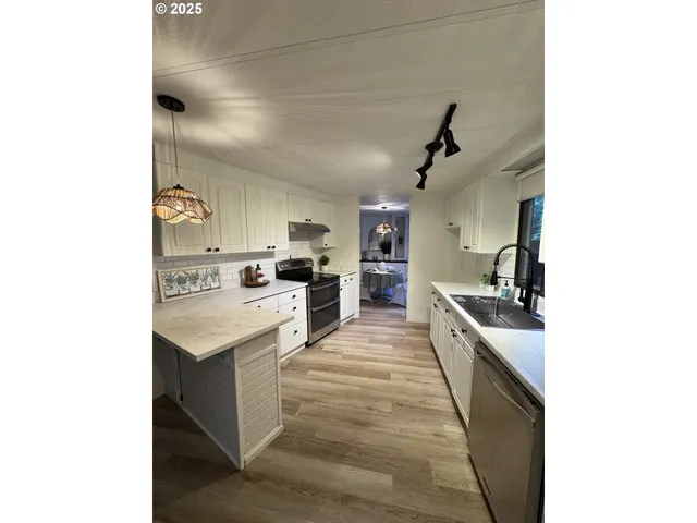 a large white kitchen with cabinets