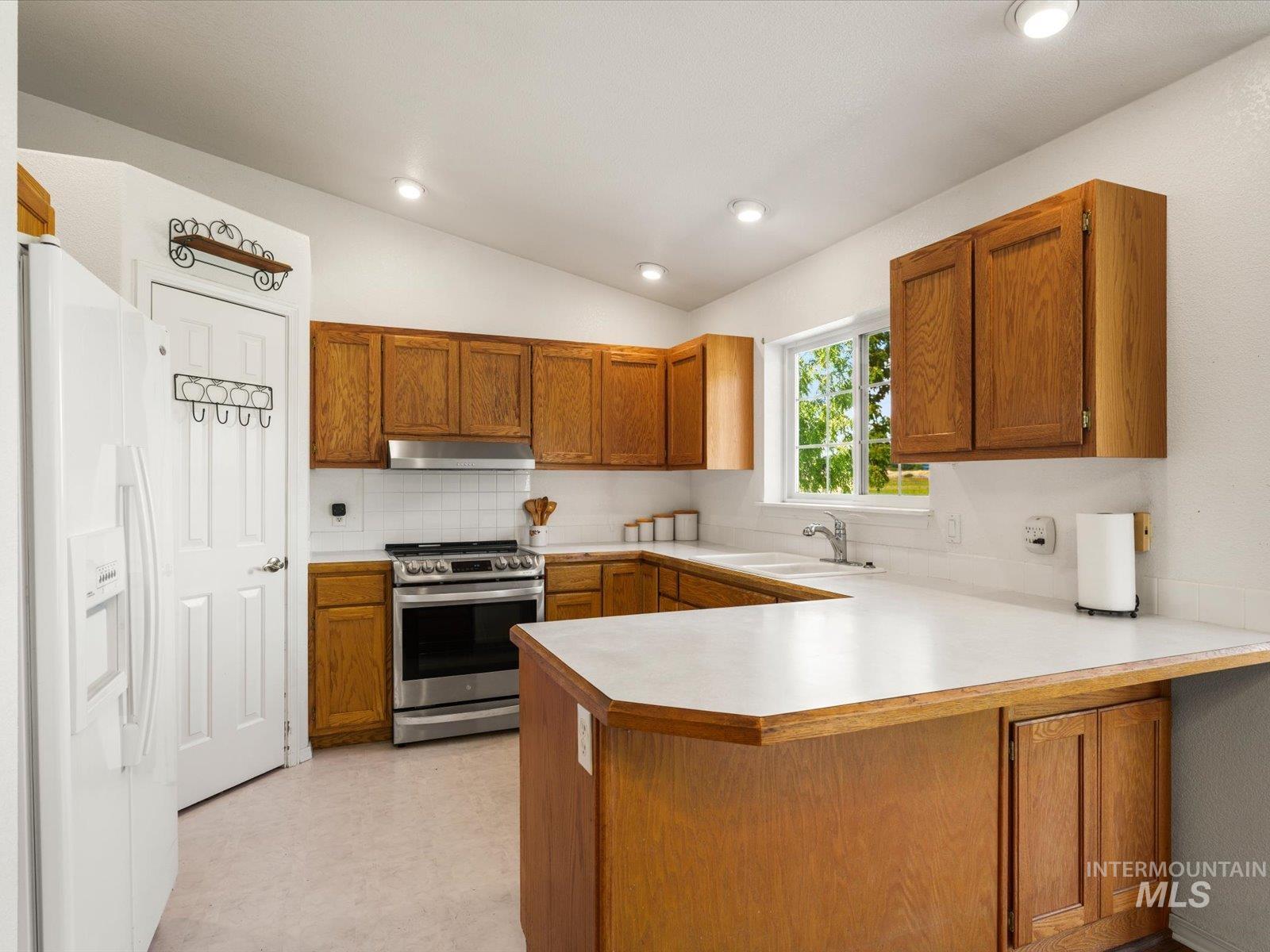 3540 Wills Road Emmett, ID 83617 - Photo 11 of 36 Kitchen featuring wood cabinetry, white countertops, tile backsplash, and stainless steel appliances