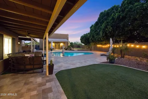a view of a patio with table and chairs potted plants and large tree