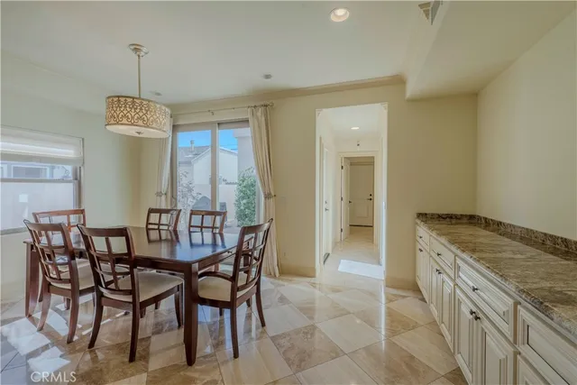 a dining hall with stainless steel appliances a dining table and chairs with wooden floor