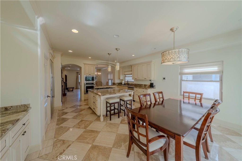 525 15th Street Huntington Beach, CA 92648 - Photo 16 of 46 a dining hall with stainless steel appliances a dining table and chairs with wooden floor