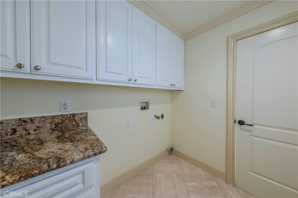 525 15th Street Huntington Beach, CA 92648 - Photo 22 of 46 a kitchen with white cabinets and a stove