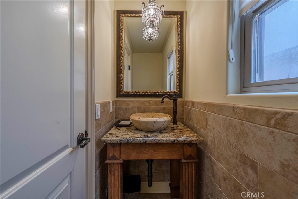 525 15th Street Huntington Beach, CA 92648 - Photo 23 of 46 a bathroom with a granite countertop sink and a mirror
