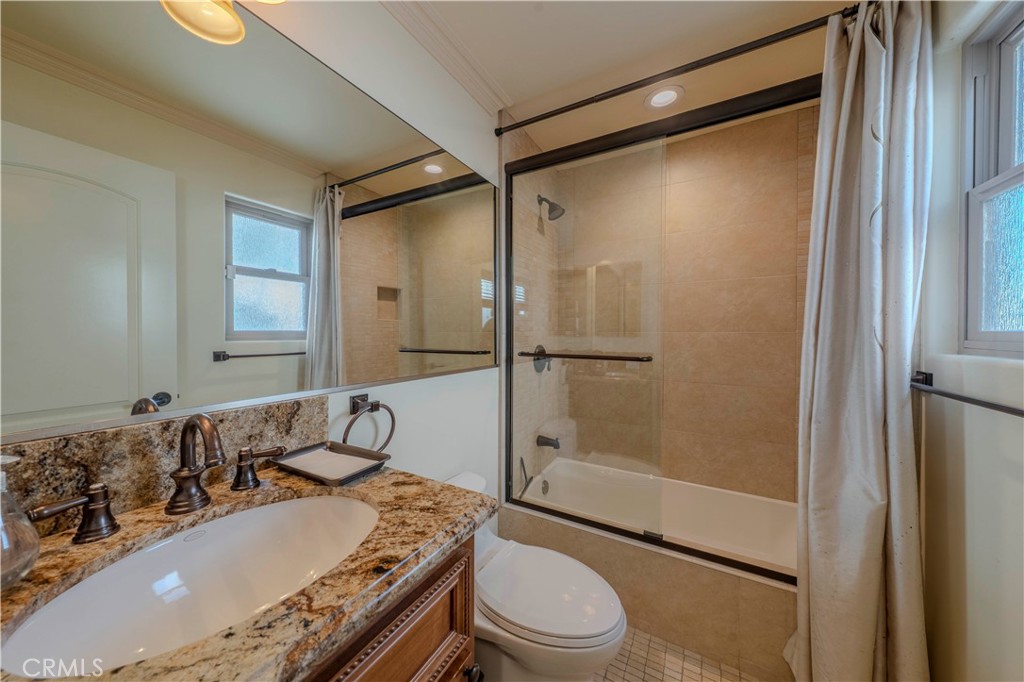 525 15th Street Huntington Beach, CA 92648 - Photo 31 of 46 a bathroom with a granite countertop sink toilet mirror and shower