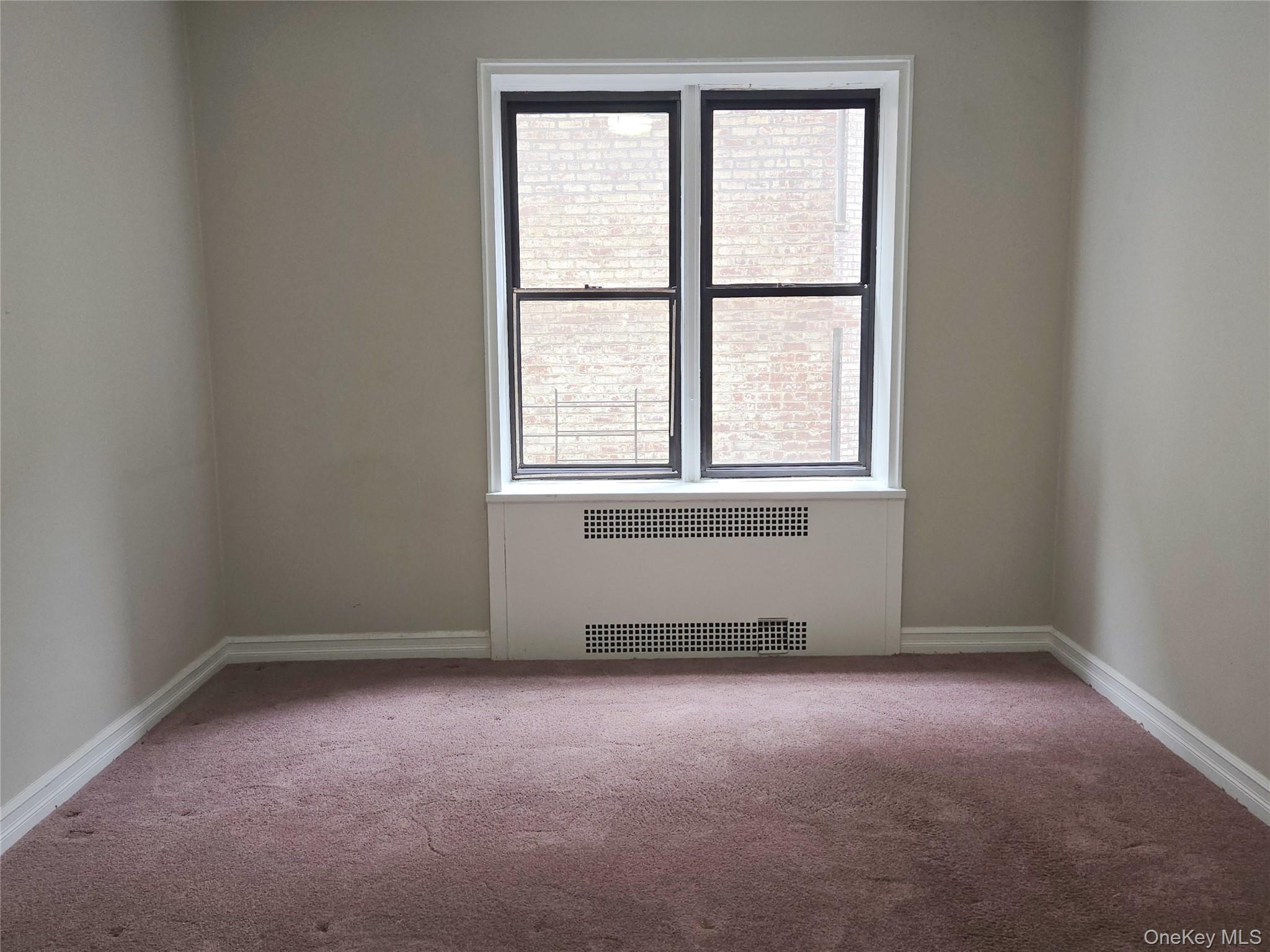 55 East 190th Street, Unit 45 Bronx, NY 10468 - Photo 12 of 13 Spare room featuring radiator heating unit and carpet floors