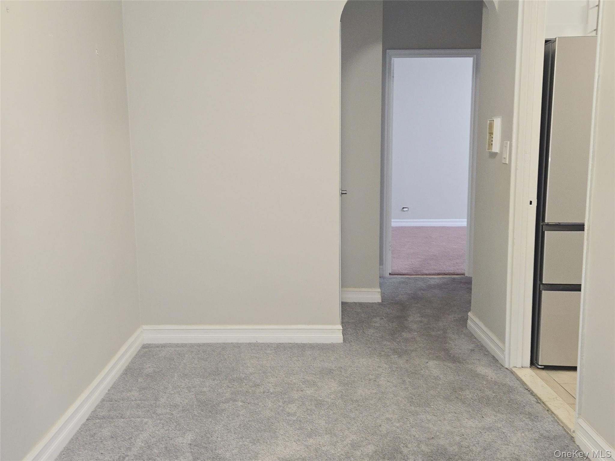 55 East 190th Street, Unit 45 Bronx, NY 10468 - Photo 5 of 13 Unfurnished room with light colored carpet and arched walkways