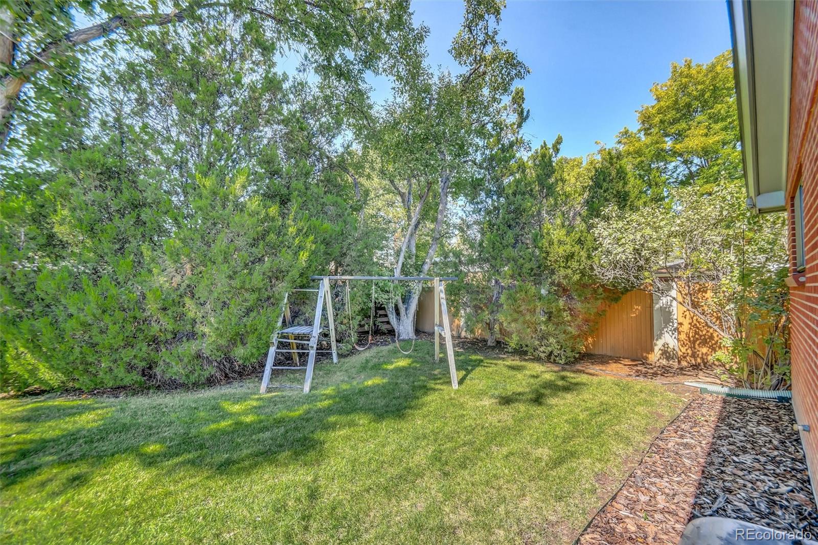 101 Hudson Street Denver, CO 80220 - Photo 25 of 27 a view of a backyard with table and chairs and wooden fence