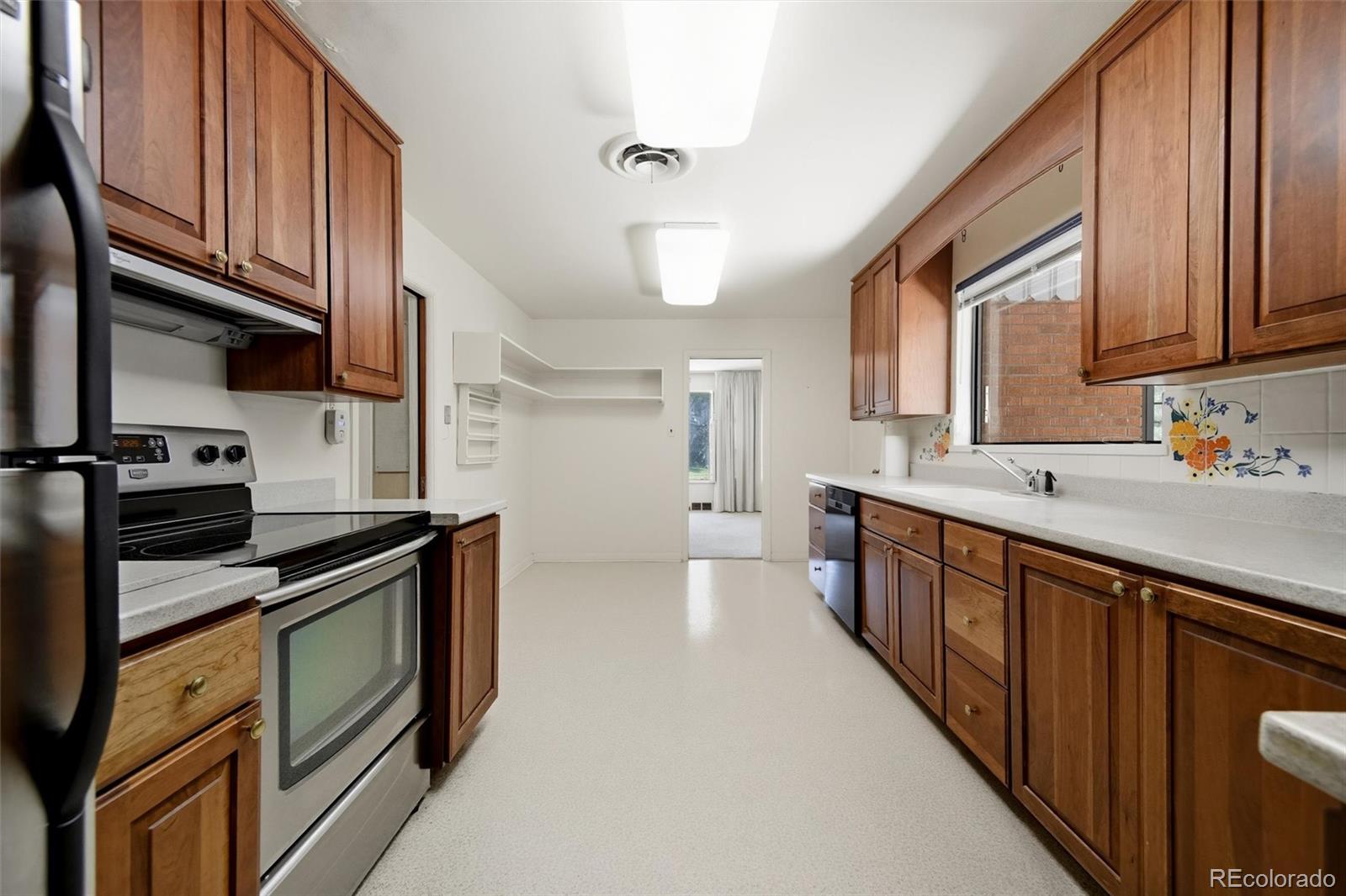 101 Hudson Street Denver, CO 80220 - Photo 7 of 27 a kitchen with stainless steel appliances granite countertop a sink a stove and a refrigerator
