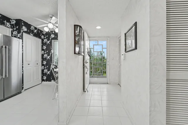 a view of a hallway with bathroom and a mirror