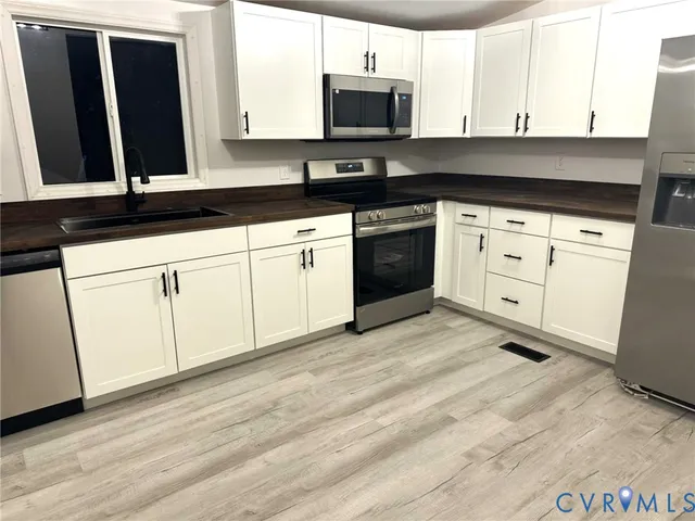 a kitchen with white cabinets and black appliances