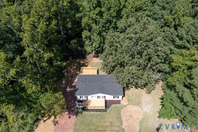 an aerial view of a house with a yard and tree s