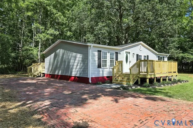 a front view of a house with a yard and trees